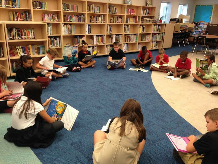 a group of kids sitting in round and studying 